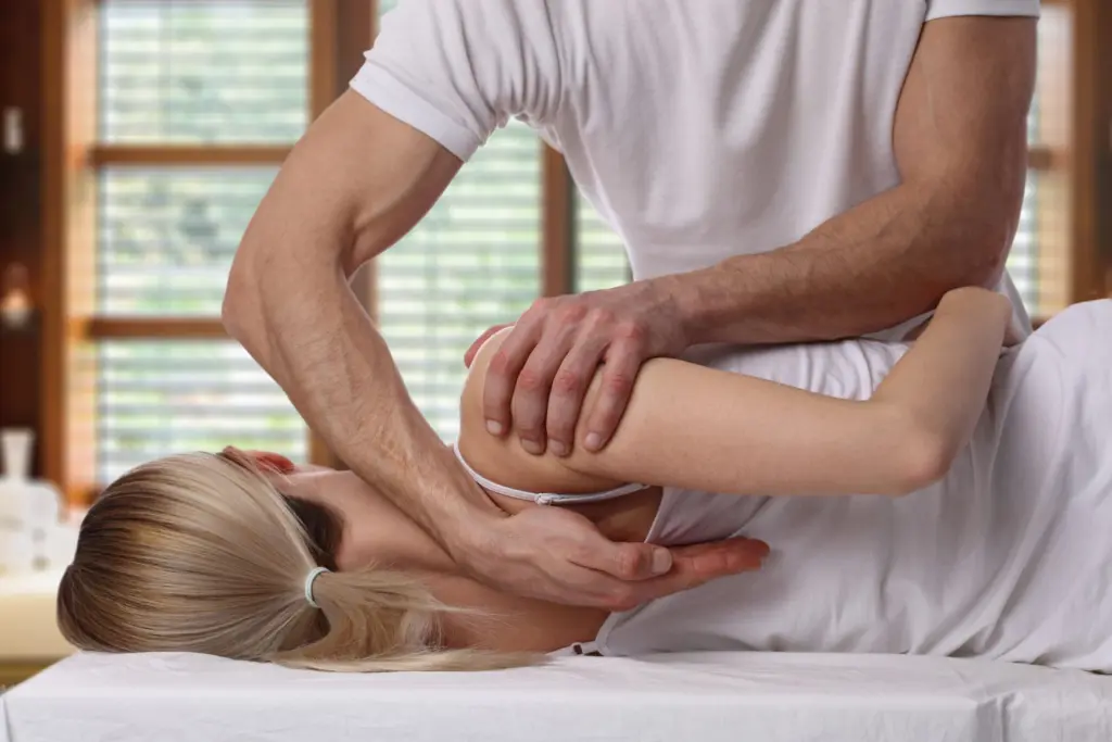 A chiropractor adjusting a patient's back on a treatment table