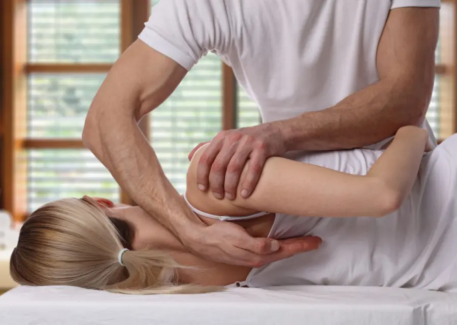 A chiropractor adjusting a patient's back on a treatment table